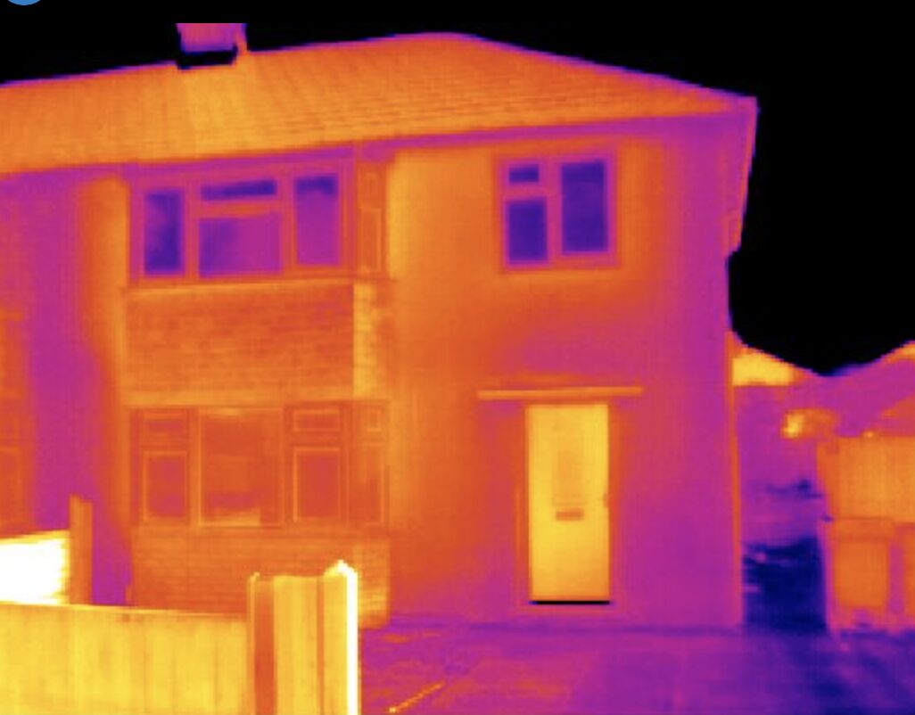 Thermal imaging of UK house showing heat loss through walls and roof before GBIS insulation installation